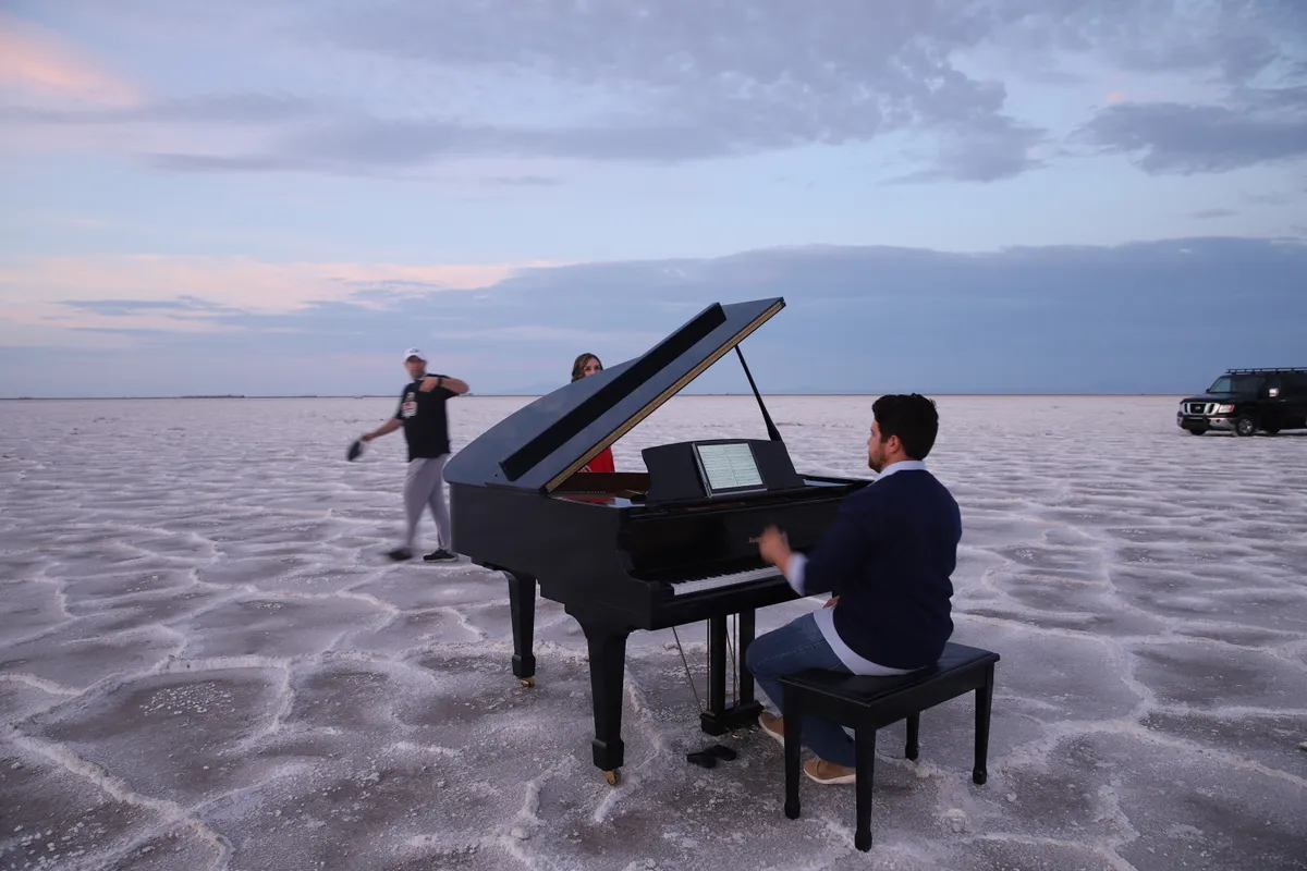Behind the scenes: a Safe and Sound Pianos crew at work on the Bonneville Salt Flats during a music video shoot, truck in the distance.