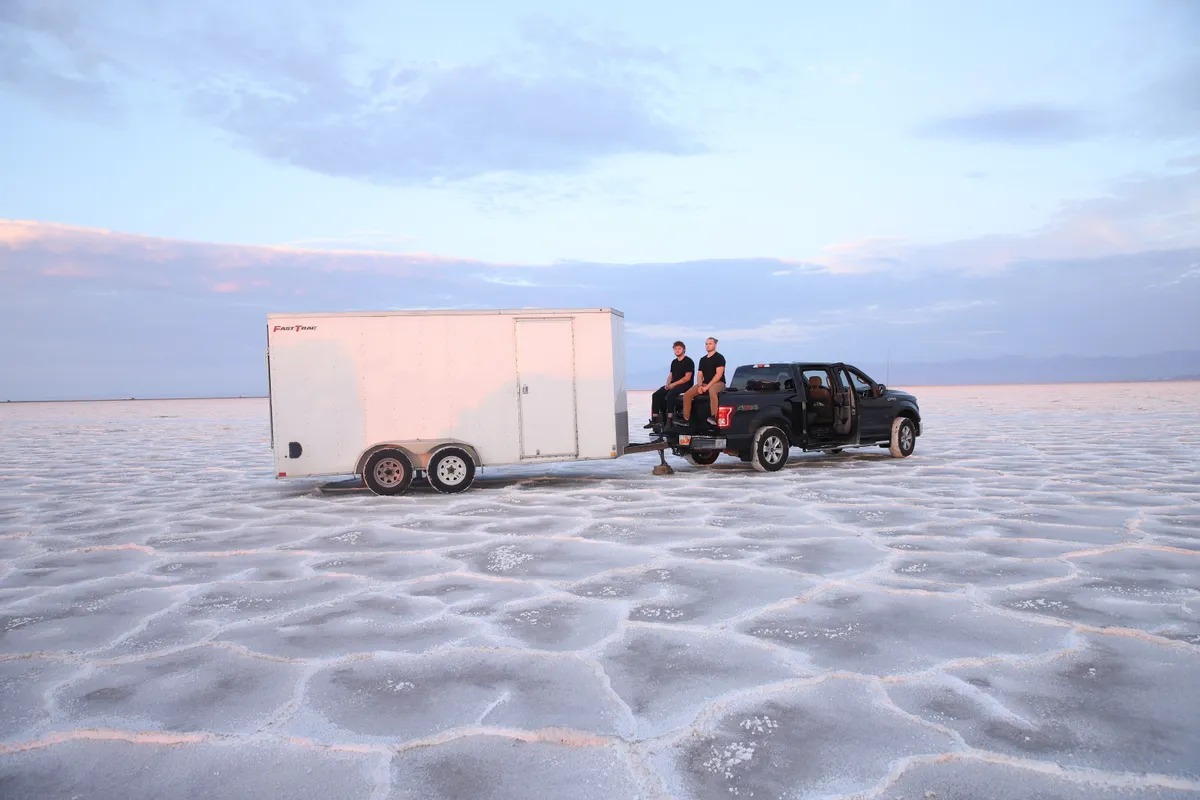 A Safe and Sound Pianos truck and enclosed trailer parked on the Bonneville Salt Flats during a long-distance piano move shoot.
