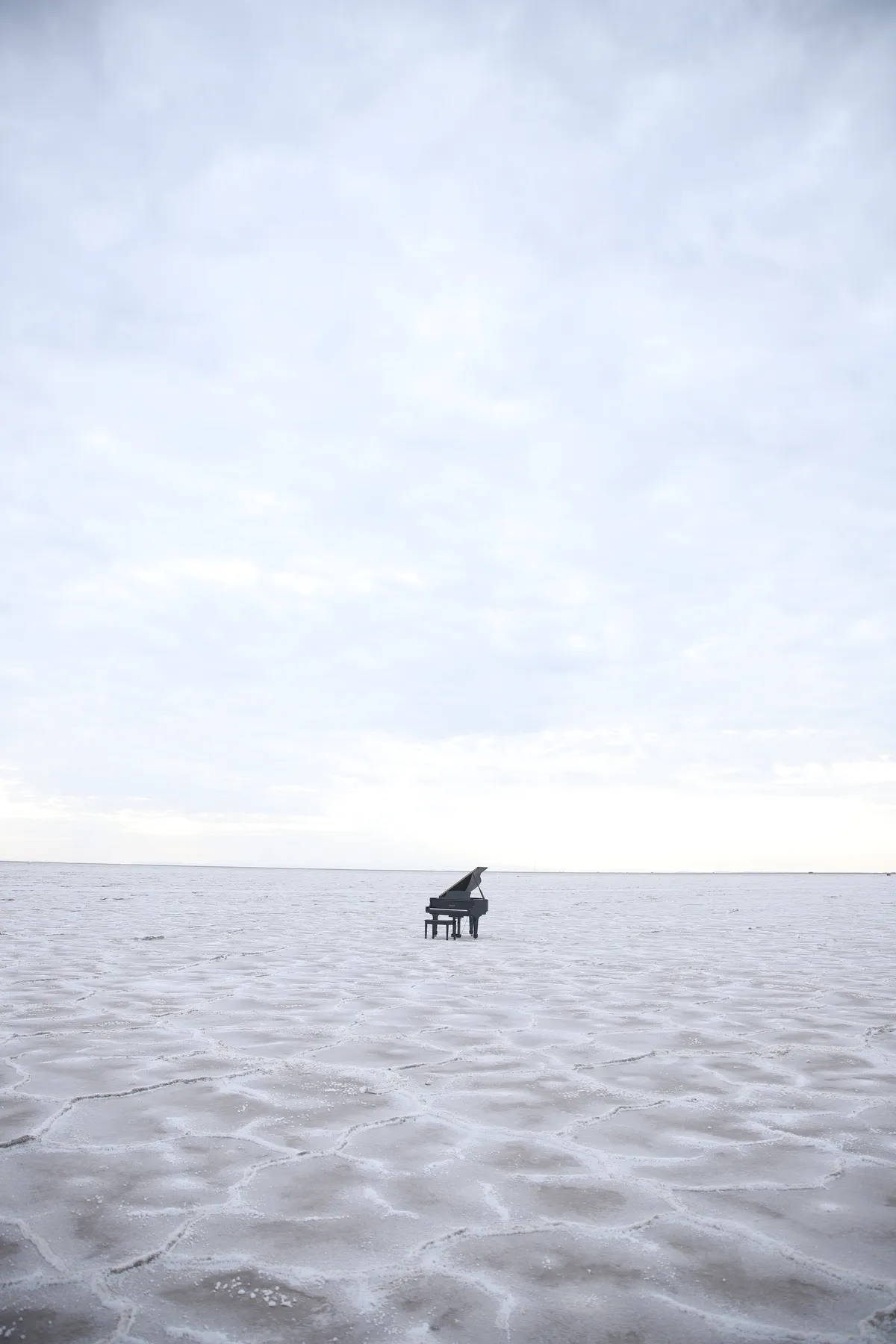 A grand piano staged on a Salt Lake City rooftop with reflective glass office towers behind — a Safe and Sound Pianos rental on location for a music video shoot.