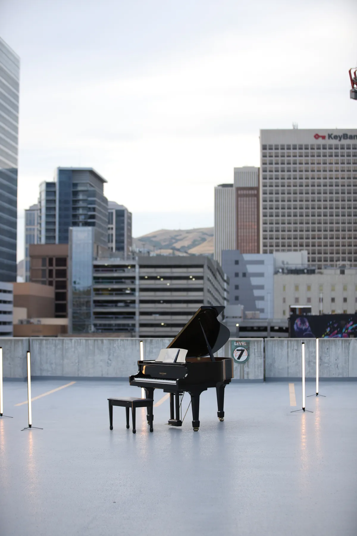 Pianist in a blue sweater playing a black grand piano on the Bonneville Salt Flats — long-exposure motion blur catches the performance.
