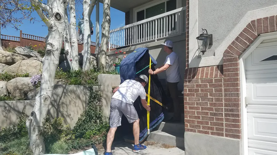Crew handling a piano at a Utah residence during an early-2017 move.