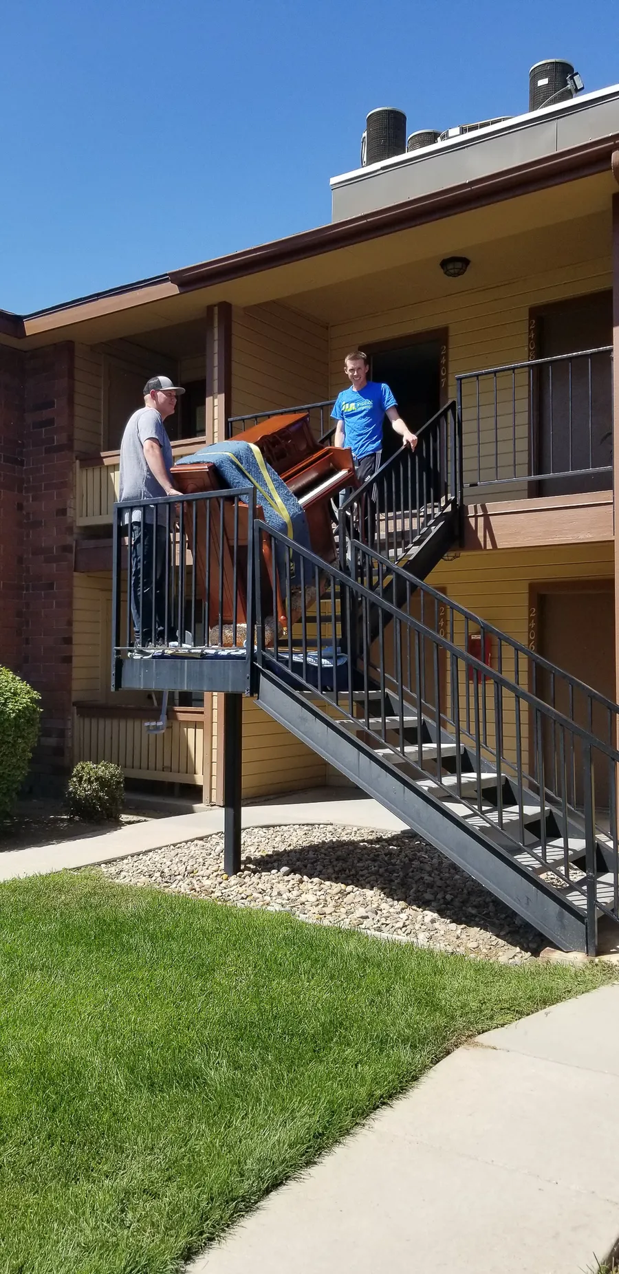 Wrapped piano mid-move at a residential location during a Safe and Sound Pianos job.