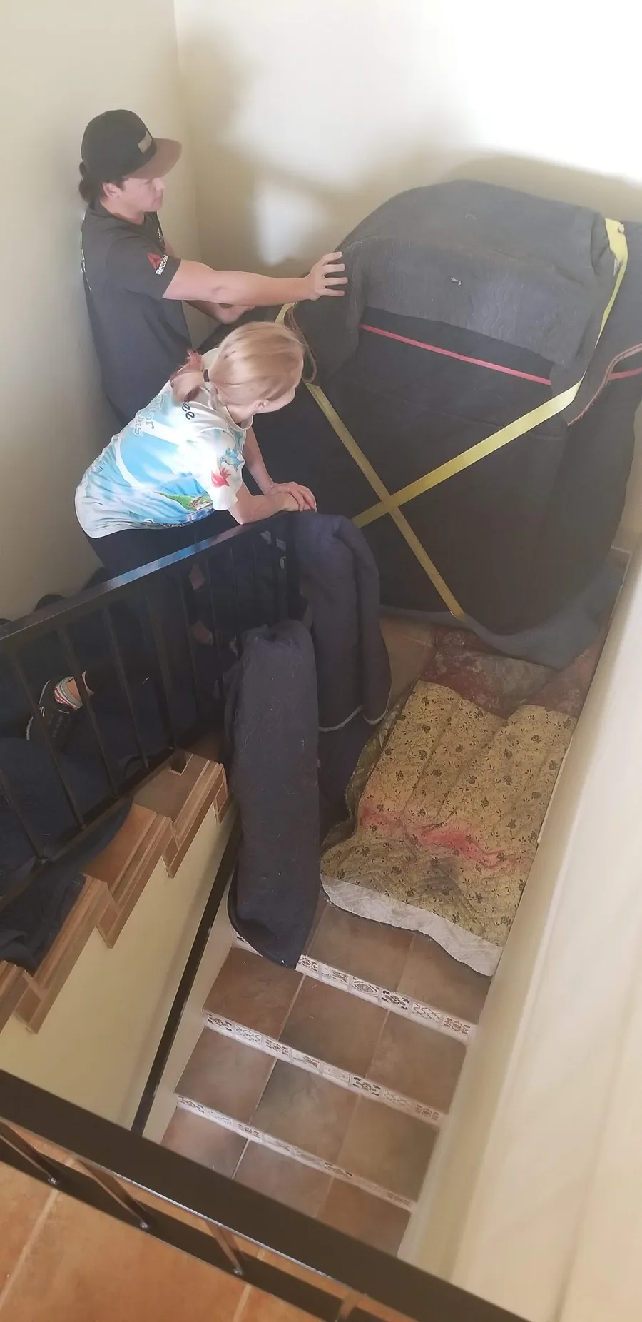 Crew working a piano through a residential entryway during a fall move in the Salt Lake Valley.