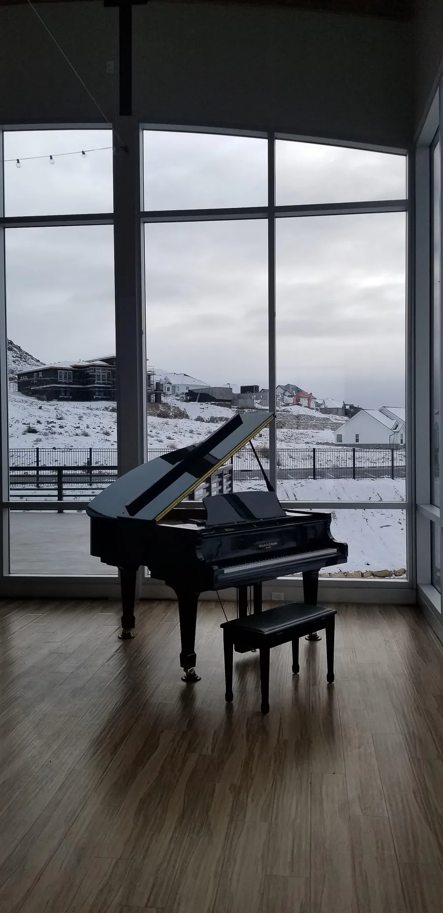 Grand piano in a glass-walled room overlooking the Salt Lake Valley.
