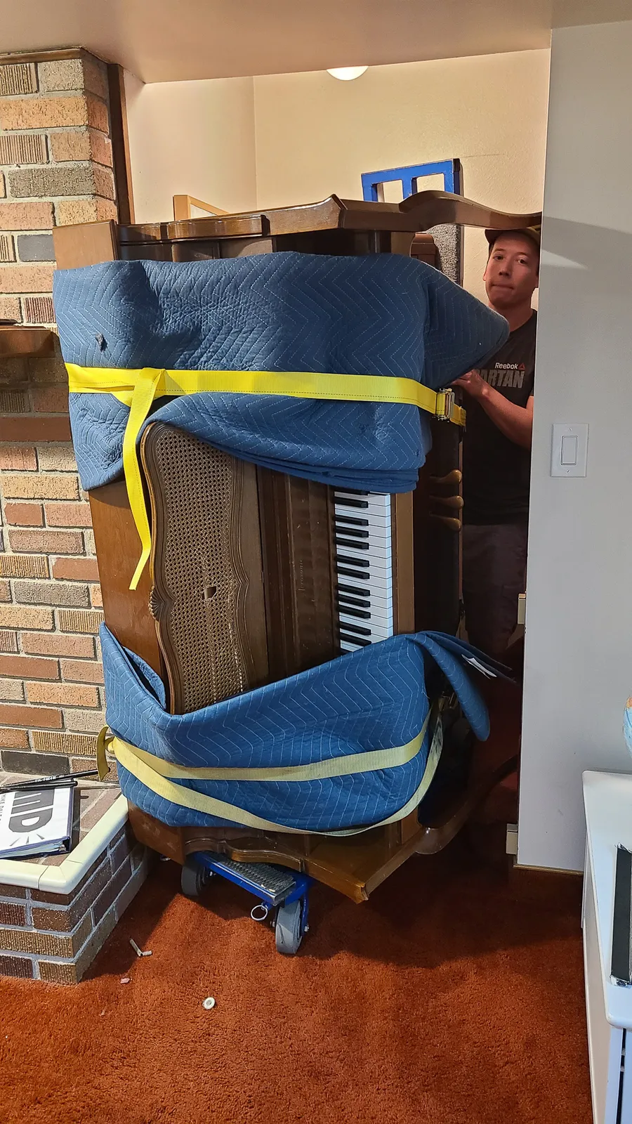 Crew positioning a wrapped piano during a Utah piano move.