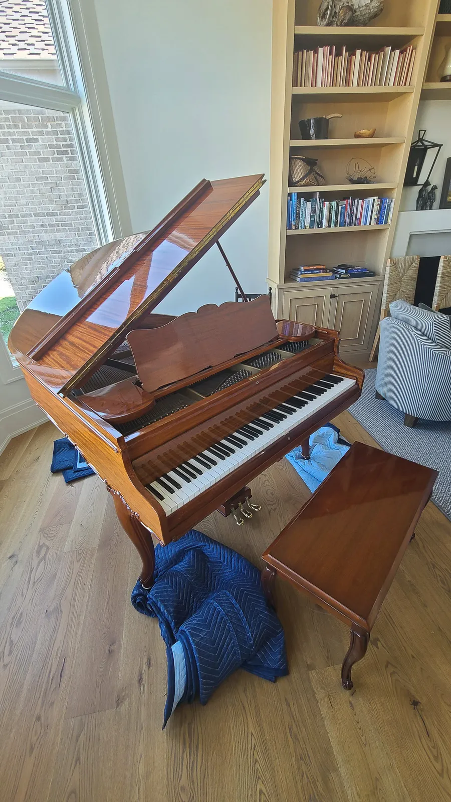 Crew handling a wrapped piano at a residential Utah location.