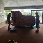 large 8 foot piano being moved in an apartment complex in salt lake city utah
